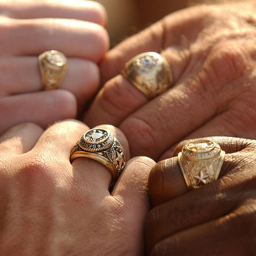 Aggies holding their aggie rings together